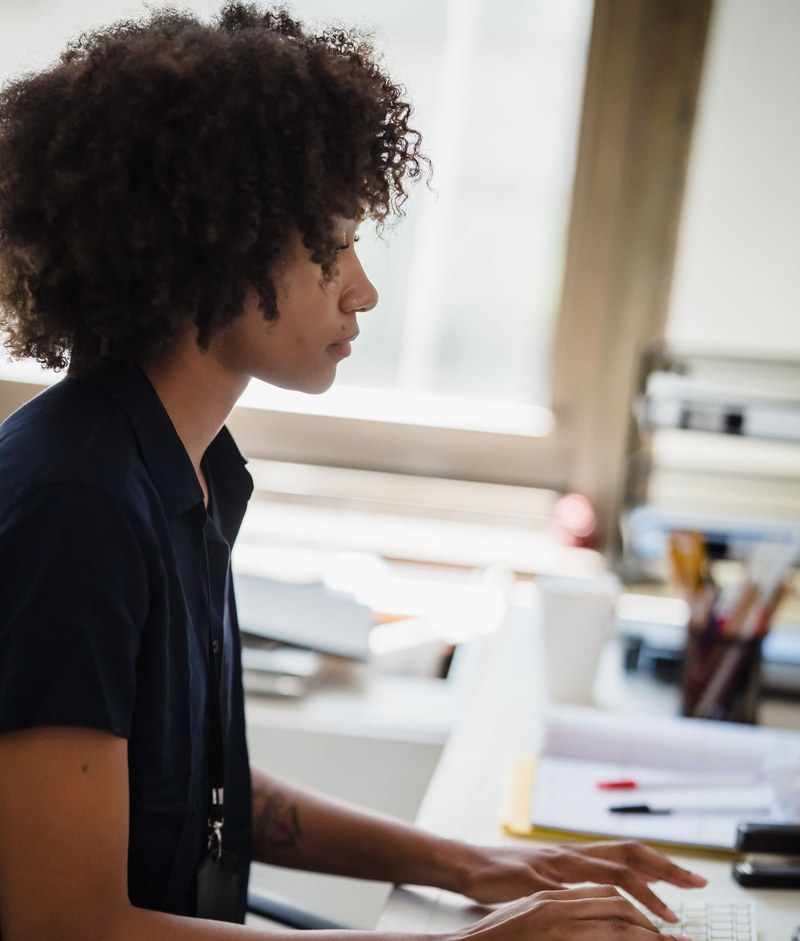 Professionnelle afro travaillant sur un ordinateur en open space